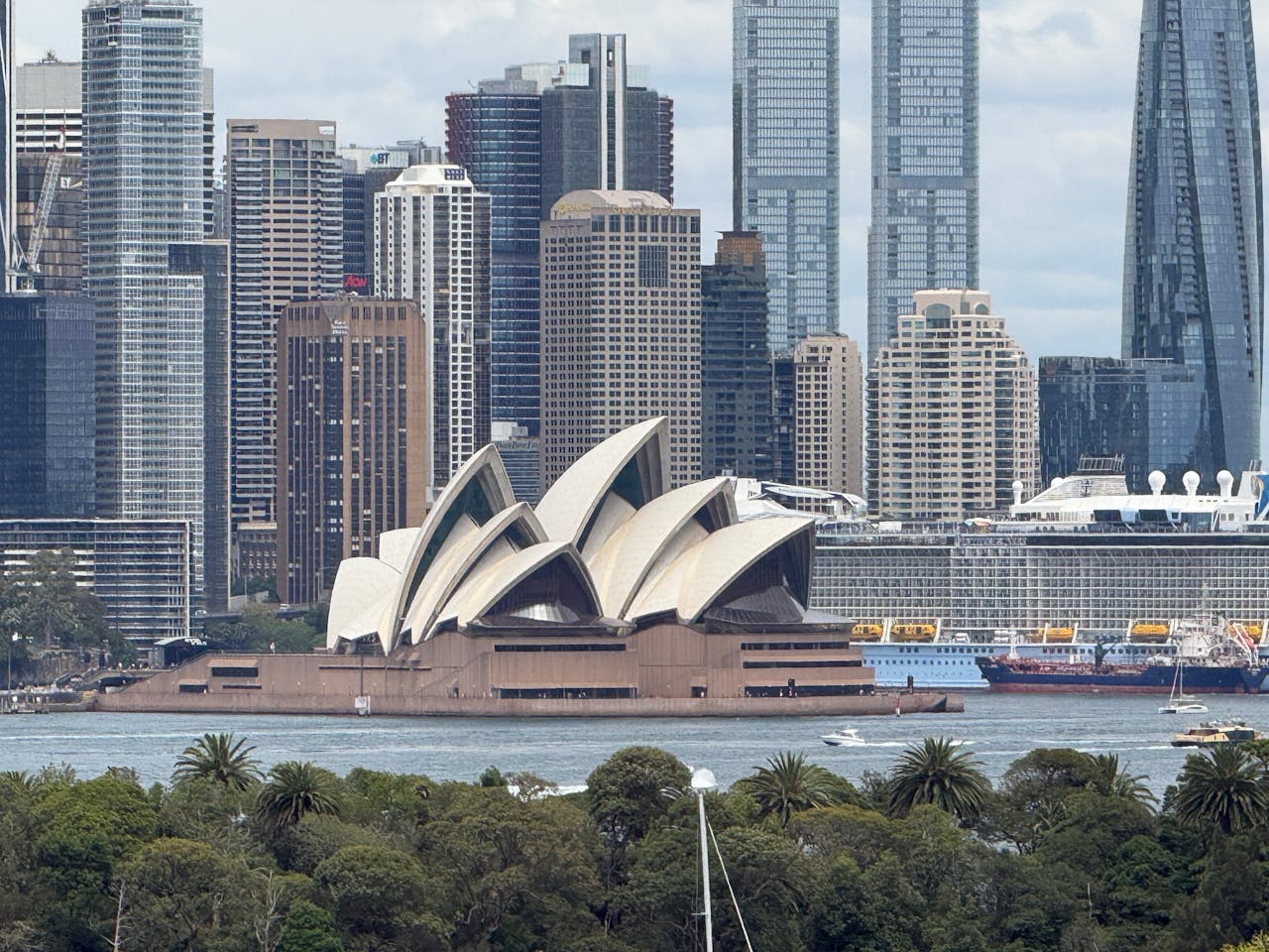services-bg View of the iconic Sydney Opera House with downtown skyline in background.